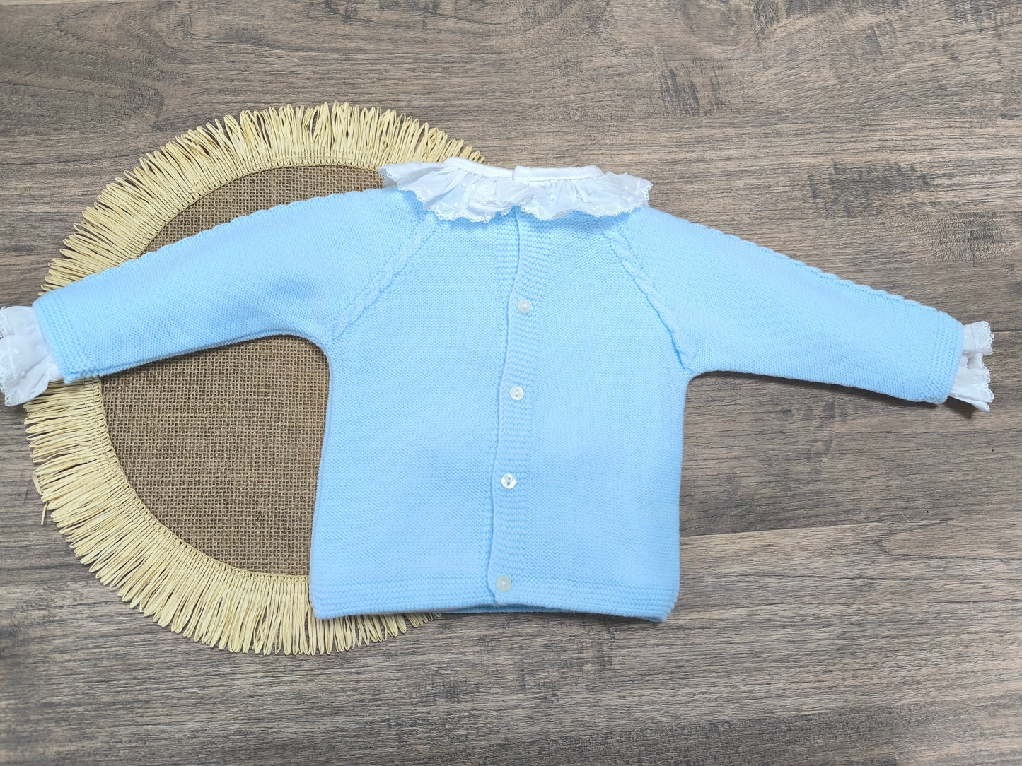 Jersey de lana azul bebé con cadenetas decorativas y botones traseros