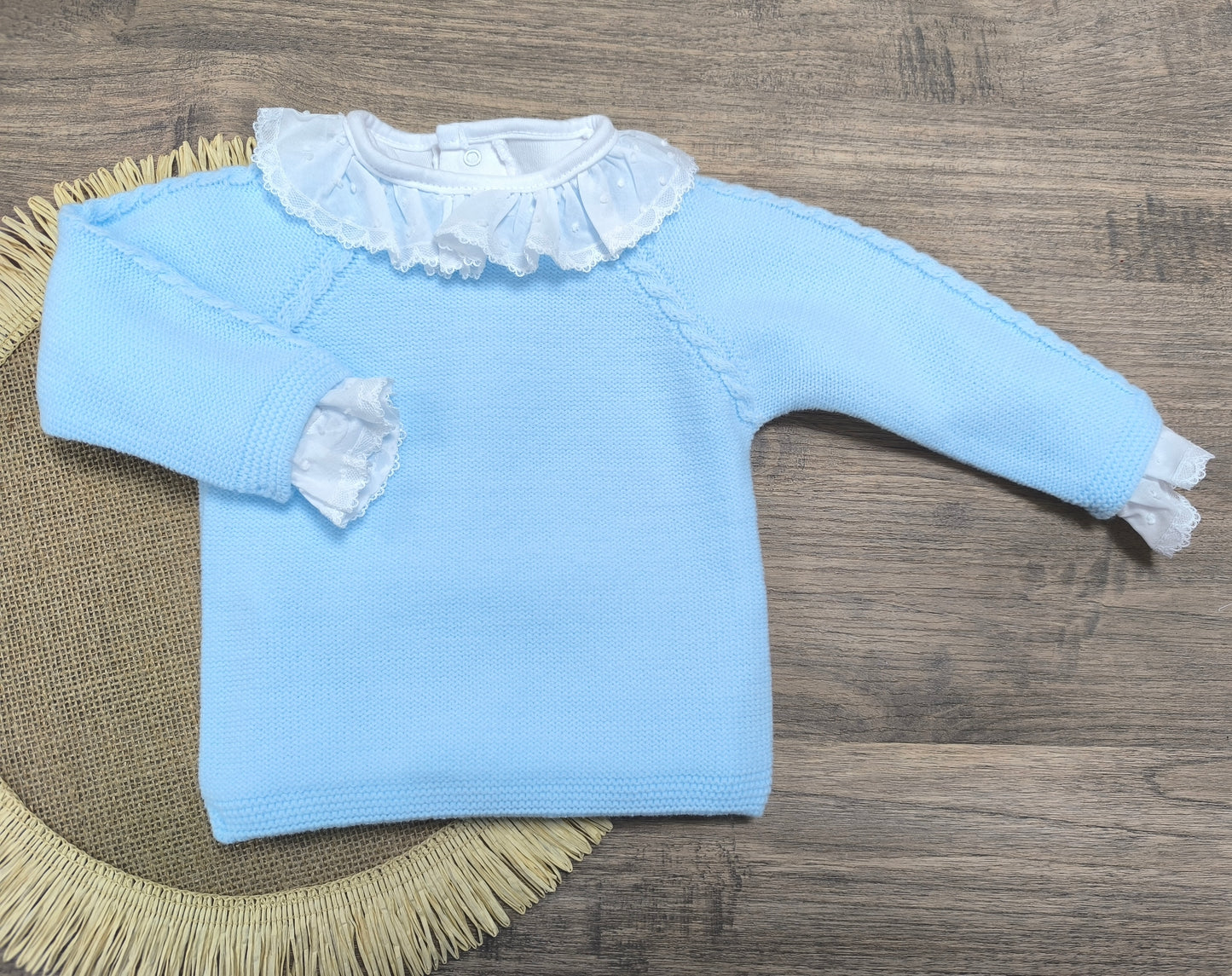 Jersey de lana azul bebé con cadenetas decorativas y botones traseros