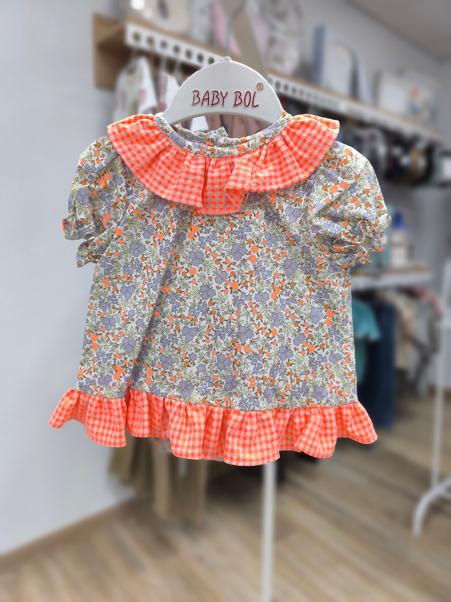 Jesusito para niña color naranja flúor con estampado de flores y cubrepañal
