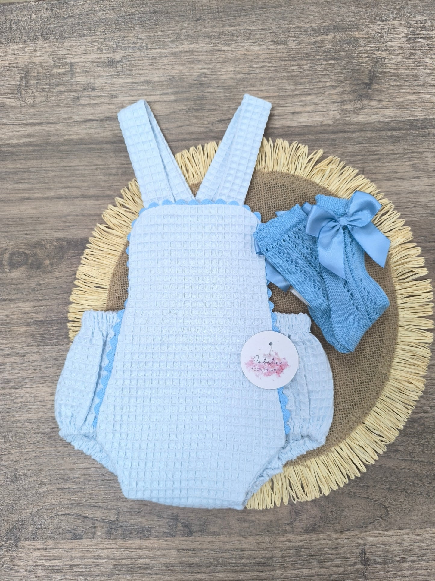Ranita de bebé unisex en color celeste de tejido waffle con tirantes y puntilla