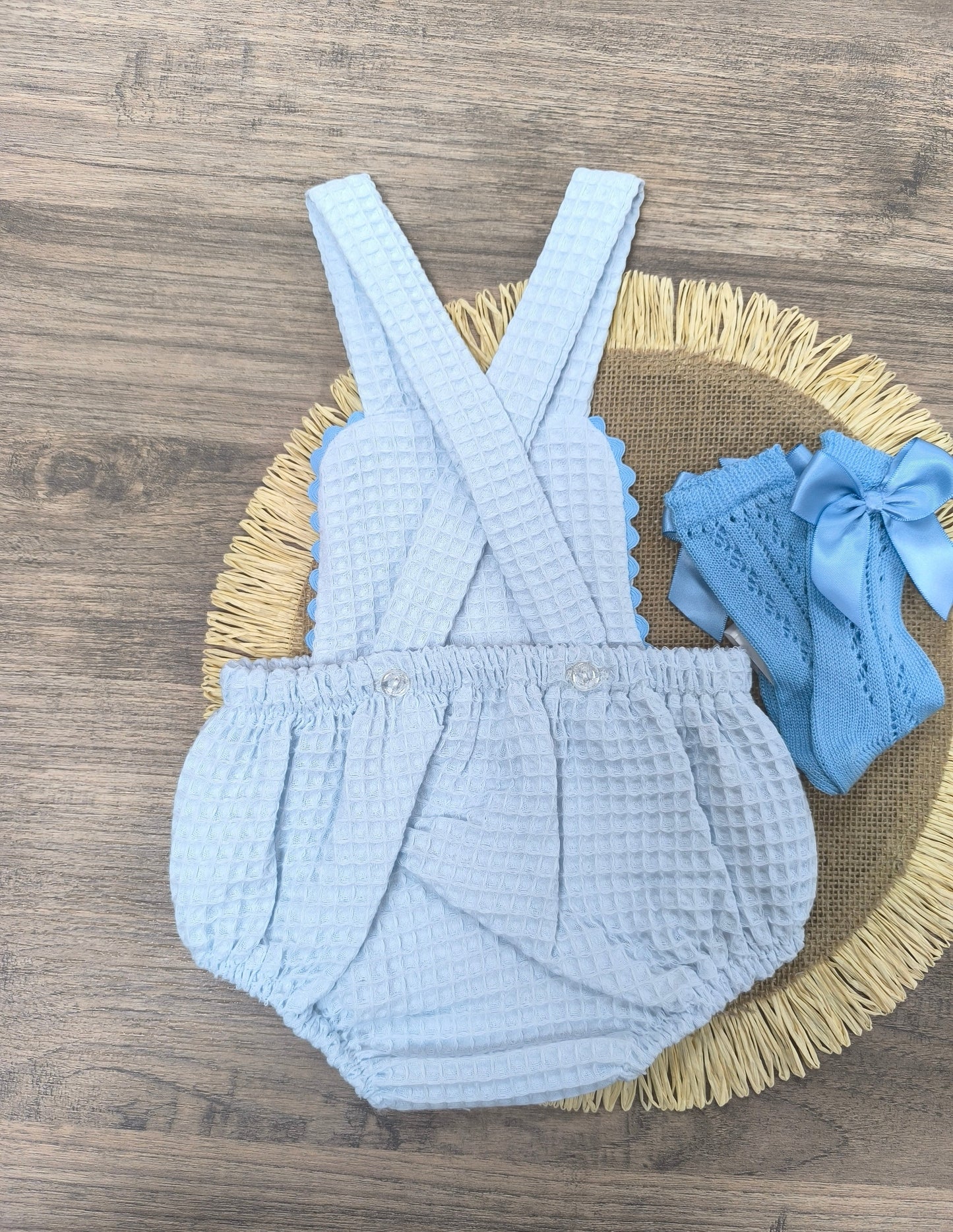 Ranita de bebé unisex en color celeste de tejido waffle con tirantes y puntilla